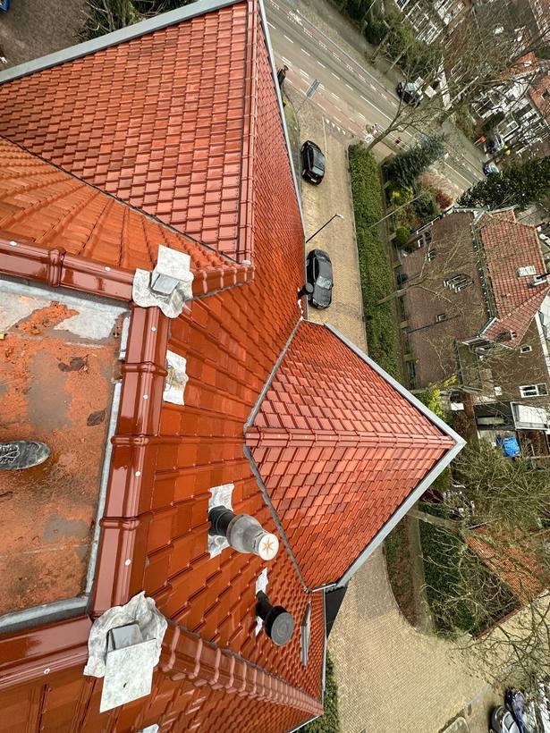 Nieuwe keramische dakpannen na renovatie van een pannendak