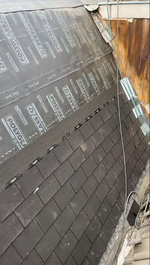 Dakdekker soldeert de naad van een nieuwe zinken dakgoot