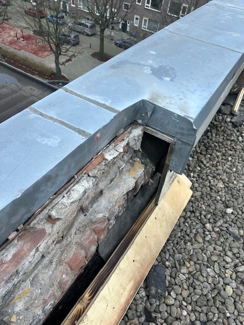 Dakrand geopend, metselwerk zichtbaar en nieuwe zinken daktrim aangebracht